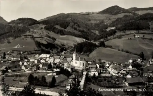 Ak Türnitz in Niederösterreich, Dorfpanorama, markante Kirche mit Turm, Wohnhäuser, Straßen, Feld
