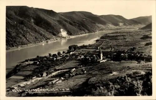 Ak Weißenkirchen in der Wachau Niederösterreich, Flussufer mit Dorf und Kirchturm, Weinberge und 