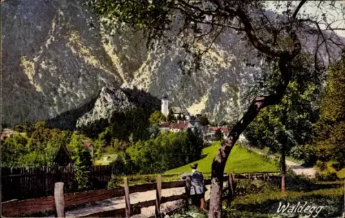 Ak Waldegg in Niederösterreich, Dorf mit Kirchturm vor steilen Bergen, eingezäunter Weg, Mann am 