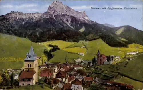 Ak Eisenerz Steiermark, Berggipfel im Hintergrund, grüne Almwiesen, Tal mit Häusern, zwei Kirchtü