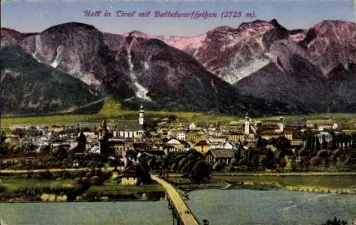 Ak Hall in Tirol, Bergkette, Fluss mit Brücke, Kirchtürme, Häuser, Wiesen im Vordergrund