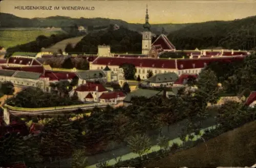 Ak Heiligenkreuz Niederösterreich, Kirchturm mit Zwiebeldach, rote Dächer, ummauerte Anlage, Bäum