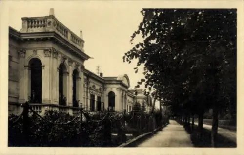 Ak Langenlois in Niederösterreich, Reihe von Fassaden links, Baumallee rechts, Gehweg, Zaun mit K