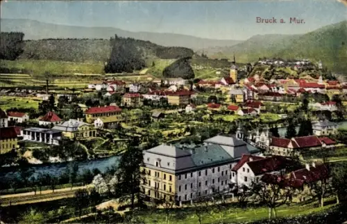 Ak Bruck an der Mur Steiermark, Fluss mit Ufer, Brücke, mehrstöckiges Gebäude im Vordergrund, Rei