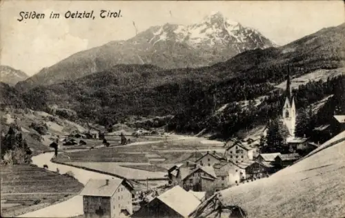 Ak Sölden in Tirol, Dorf mit Kirchturm, Häuser am Hang, Tal mit Feldern und Fluss, schneebedeckte