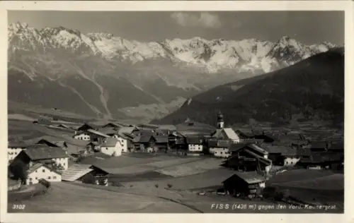 Ak Fiss in Tirol, Kirchturm, Dorf mit Häusern und Höfen, Wiesen/Felder, schneebedeckte Gipfel, (1