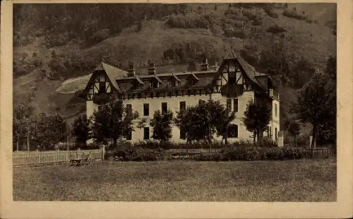 Ak Bad Hofgastein in Salzburg, Mehrstöckiges Gebäude mit Giebeln und Gauben, Baumreihe, Wiese mit