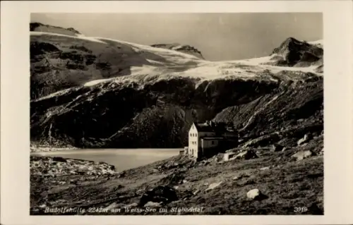 Ak Stubach Uttendorf in Salzburg, Rudolfshütte, Hütte am See, 2242 m, steiniger Vordergrund, Glet