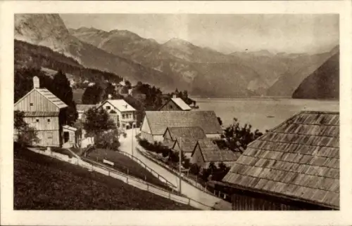 Ak Grundlsee Salzkammergut Steiermark, See, Berge, Uferstraße mit Zaun, Häuserreihe und Bootshäus