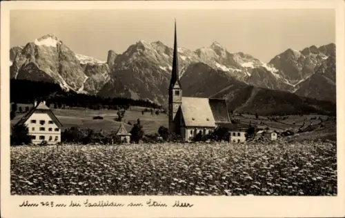 Ak Saalfelden am Steinernen Meer in Salzburg, Kirche mit hohem Turm, Blumenfeld, mehrere Häuser, 
