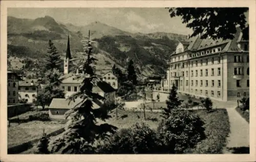 Ak Bad Hofgastein in Salzburg, Kirchturm, Nadelbäume, großes mehrstöckiges Gebäude, Fußweg, Wiese