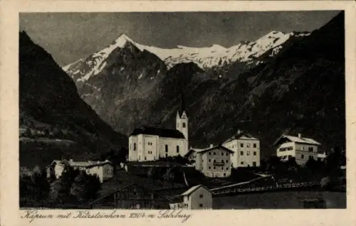 Ak Kaprun in Salzburg, Dorf mit Kirche und Turm, mehrere Häuser, hohe schneebedeckte Berge, Wiese