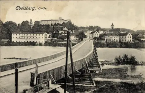 Ak Ebelsberg Linz in Oberösterreich, Holzbrücke über Fluss, breite Fahrbahn, Uferhäuser, Kirchtur