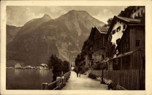 Ak Hallstatt im Salzkammergut Oberösterreich, Uferweg am See, Holzhäuser rechts, Berge im Hinterg