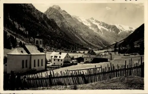 Ak Gschnitz in Tirol, Bergtal mit schneebedeckten Gipfeln, Holzzaun im Vordergrund, Häuser, Kirch