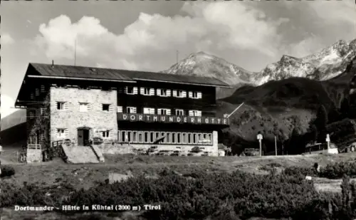 Ak Kühtai Tirol, Berghütte aus Stein und Holz, 'DORTMUNDERHÜTTE' auf Fassade, Berggipfel, Wiese