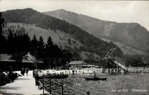 Ak Zell am See in Salzburg,  Strandbad, Menschen am Strand, Schwimmer, Boote, Berge im Hintergrun