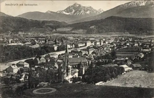 Ak Innsbruck in Tirol, Stadtpanorama mit Berggipfel, Kirche mit hohem Turm, Reihenhäuser, Wiese m