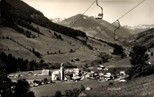 Ak Saalbach Hinterglemm in Salzburg, Sessellift-Stühle, Tal mit Dorf und Kirchturm, verstreute Ba