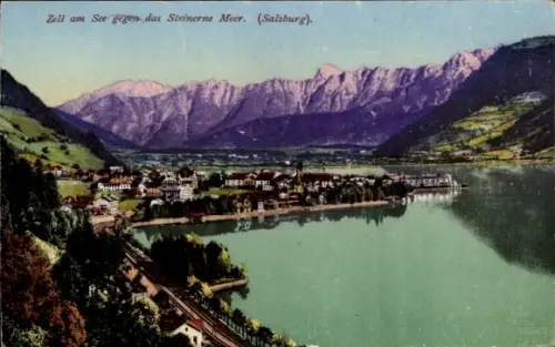 Ak Zell am See in Salzburg, Seeufer mit Ort, Eisenbahn am Ufer, Häuser und Promenade, Gebirgszug 