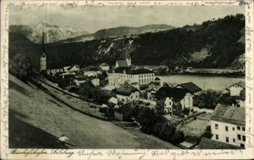 Ak Bischofshofen in Salzburg, Kirchturm, Flussufer mit Häusern, Wohnhäuser, Hügel und Berge im Hi