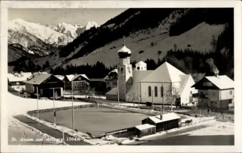 Ak St. Anton am Arlberg Tirol Österreich, Kirche, Winteransicht, Eisbahn