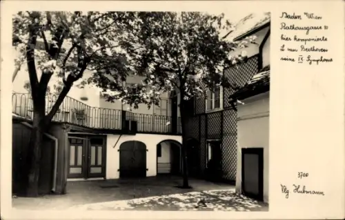 Ak Baden bei Wien in Niederösterreich, Innenhof mit Baum, Balkon mit Geländer, Arkaden/Türen, Rau