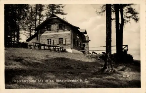 Ak Böheimkirchen Niederösterreich, Holzhütte am Hang, Bänke/Tische außen, Hohe Nadelbäume, Geländ