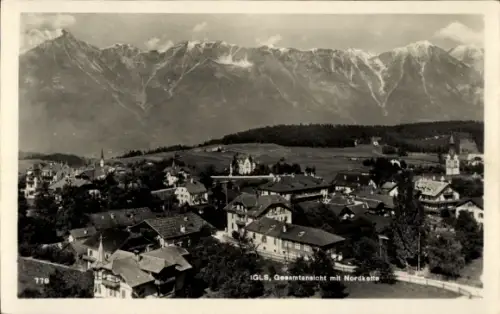 Ak Igls Innsbruck in Tirol, Bergkette im Hintergrund, Dorf mit vielen Häusern, Kirchturm sichtbar