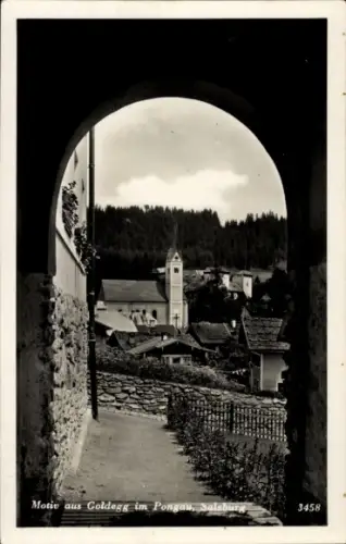 Ak Goldegg in Salzburg, Blick durch Torbogen, Fußweg, Steinmauer, Dorf mit Kirchturm, bewaldete H