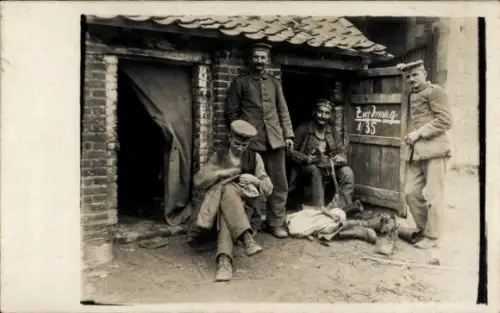 Foto Ak deutsche Soldaten in Uniform vor einem Unterstand, beim Stiefelputzen