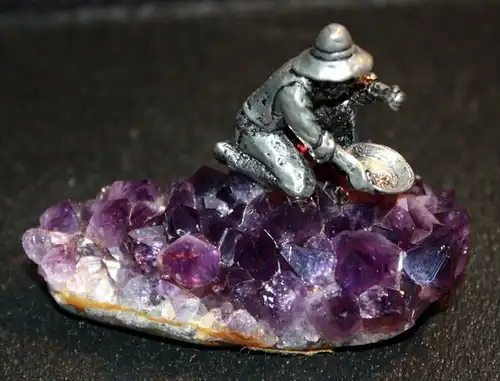 Kleine Amethyststufe mit Goldsucher Dat. 1981 und undeutlich Signiert, Metallguss, kniende miniaturhafte Gestalt beim Go