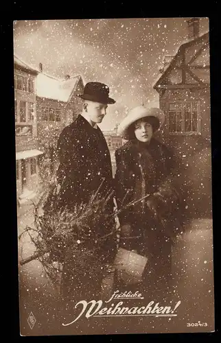 Foto-AK Weihnachten: Ehepaar mit Weihnachtsbaum im Schneefall, ungebraucht
