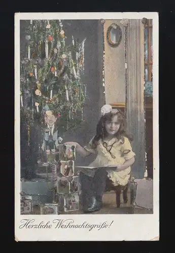 Herzliche Weihnachtsgrüße Kind neben geschmücktem Weihnachtsbaum, beschriftet 