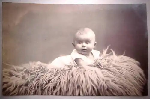Antike Postkarte / Echtfoto "Baby auf Schaffell"