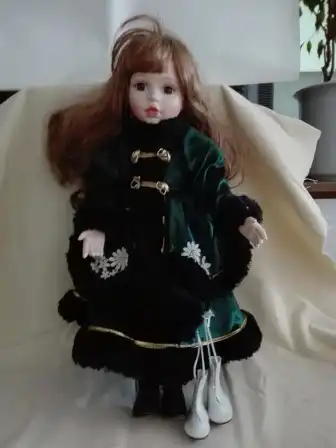 Porzellanpuppe mit Muff und Eislaufschuhen