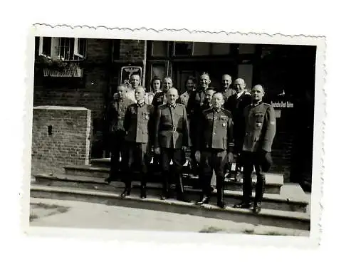 GG: Foto Postbeamte vor Postamt, Postamtsschild und Briefkasten DPO