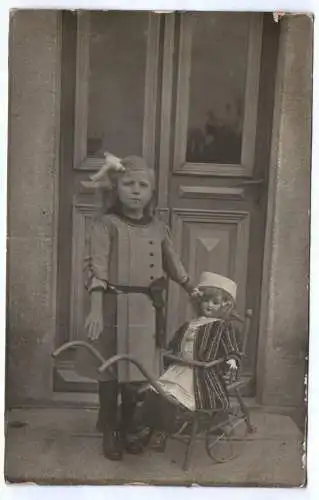 Foto Ak Mädchen mit Porzellankopfpuppe Spielwaren Puppe 1910 er