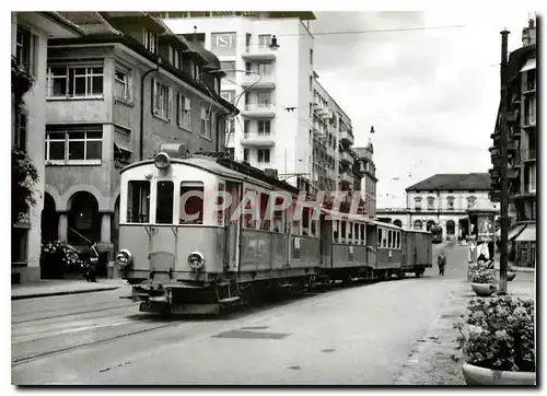 Cartes postales moderne Convoi dans les rues de Zug. Au fond devant la gre  un tram du ZBB. Vers 1950  Photo F.Stauble