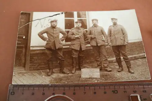altes Foto - vier Soldaten mit traurigem Gruss auf dem Schild