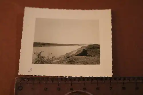 tolles altes Foto - Soldat mit Fernglas liegt am Ufer vom Fluß