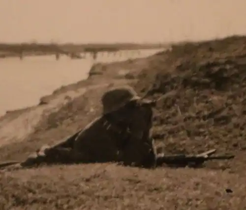 tolles altes Foto - Soldat mit Fernglas liegt am Ufer vom Fluß