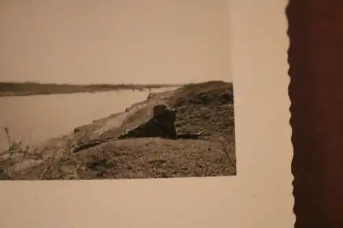 tolles altes Foto - Soldat mit Fernglas liegt am Ufer vom Fluß