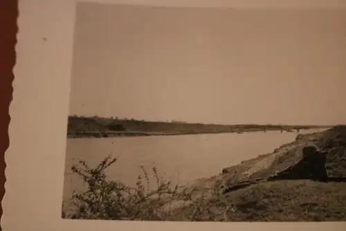 tolles altes Foto - Soldat mit Fernglas liegt am Ufer vom Fluß