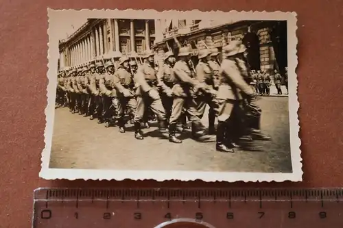 altes Foto Soldaten marschieren durch Stadt - Ort ??rückseitig beschrieben 1940