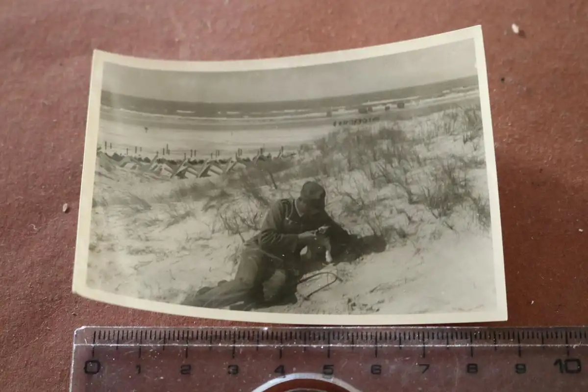 tolles altes Foto - Soldat mit Welpe am Strand - Panzersperren ? Ort ?