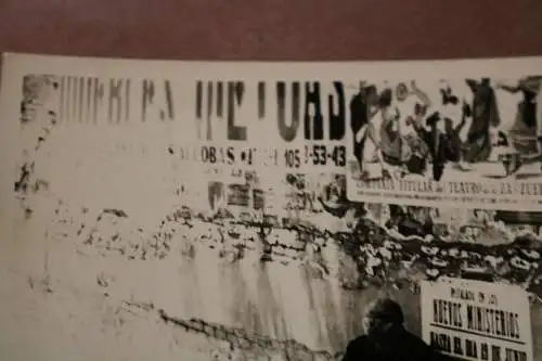 altes Foto - alte Frau sitzt an Mauer mit Plakaten - Spanien ?? 