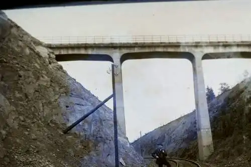 altes Glasnegativ - Mann auf  Bahnstrecke, darüber eine Brücke