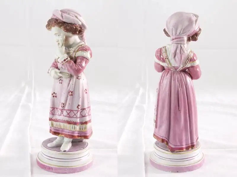 Porzellanfigur,
Ende 19. Jh., wohl Thüringen, Mädchen mit Löffel und Schüssel in der Hand, zartrosa bemalt, originelle Ausformung, an Löffel und Schüssel Restaurierungen, sonst unbeschädigt.
 2