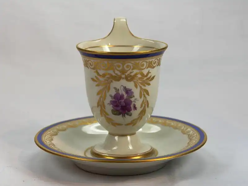 3 Tassen und Untertassen, um 1914/17, gemarkt KPM, auf Schauseiten in goldumrandeten Kartuschen Blumenmalerei (Veilchen und Rosen), Tassenrand und Unterteller mit Goldornamentik und blauem Rand verziert, unbeschädigt. H: 11 cm 2